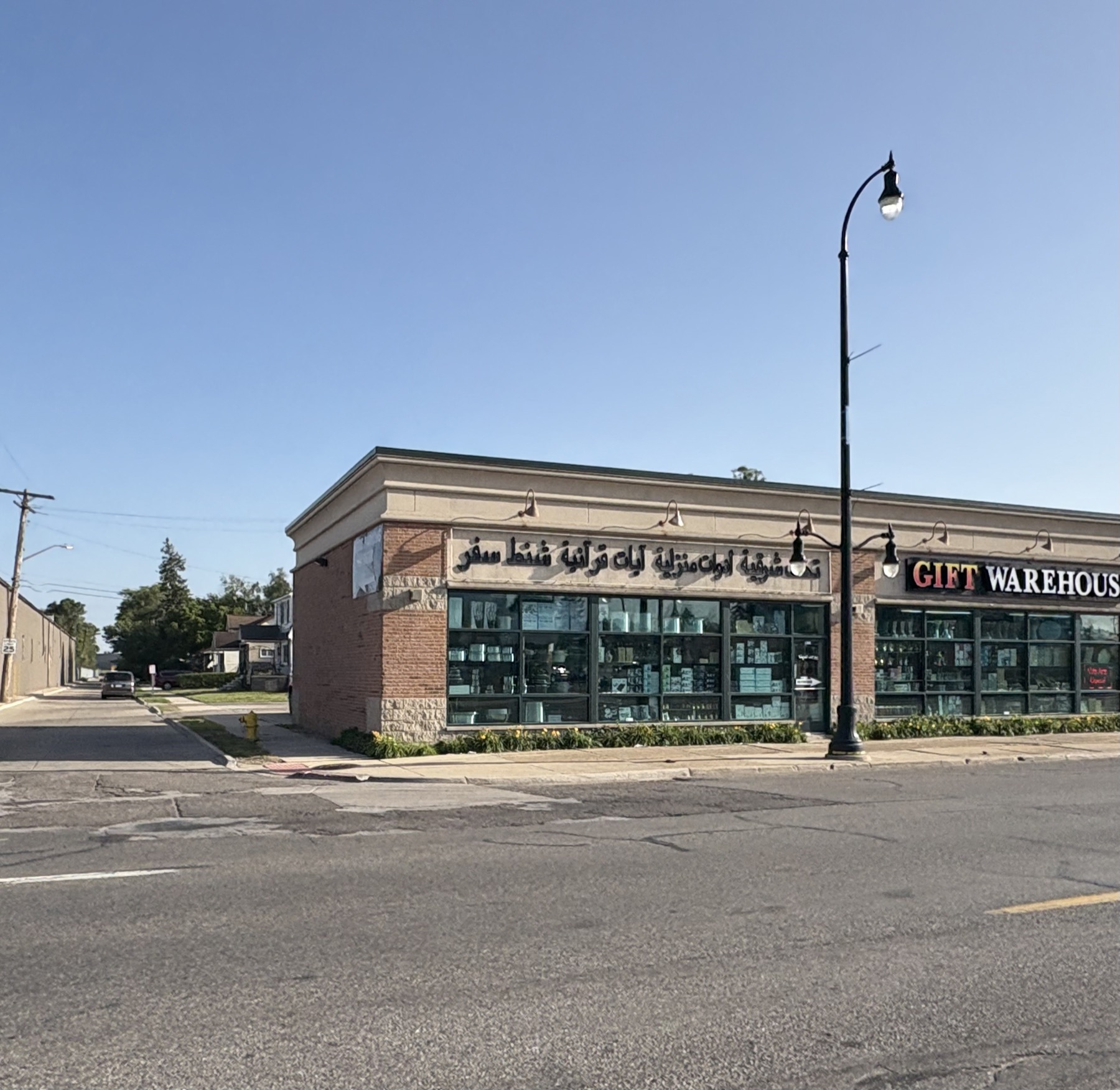 A corner shop in Dearborn whose fascia lists its goods in Arabic, with the words Gift Warehouse in English around the corner.